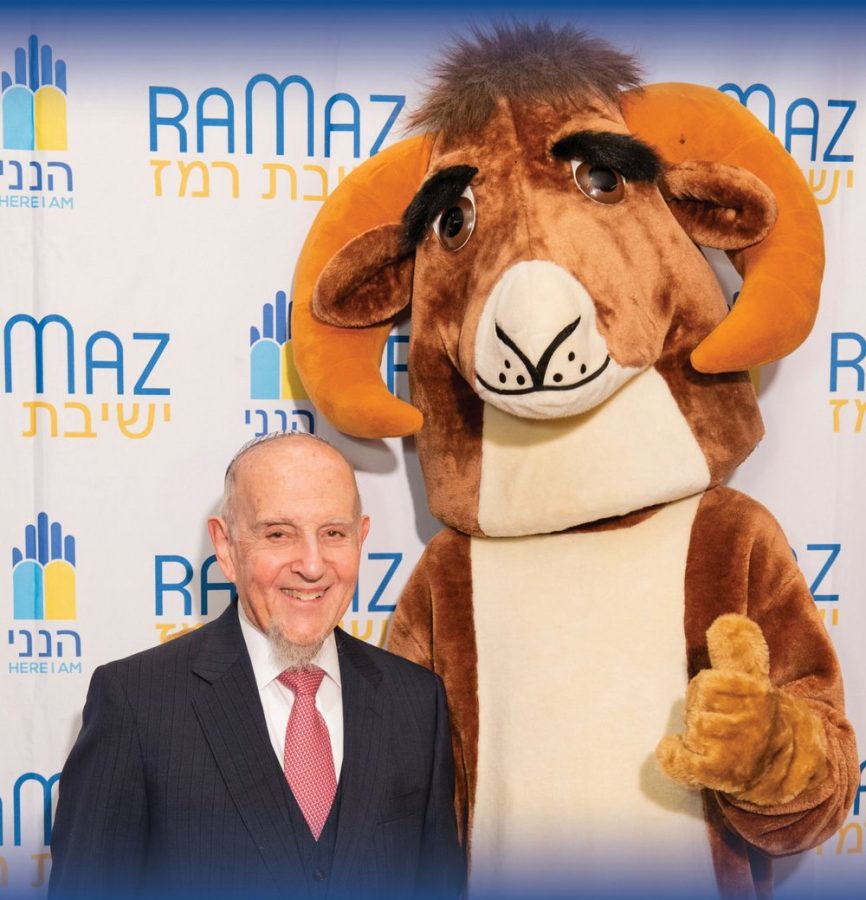Rabbi+Lookstein+and+the+Ram+mascot+pose+at+the+Ramaz+dinner+with+the+Ramaz+logo+as+the+background.