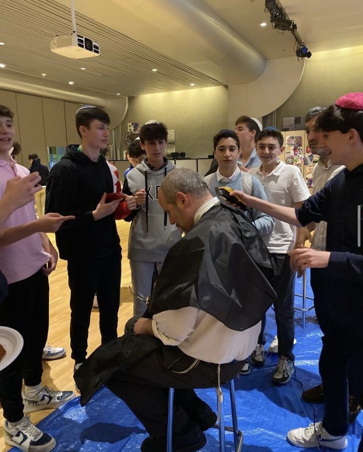 Mr. Deutsch receives a 
haircut from a student.